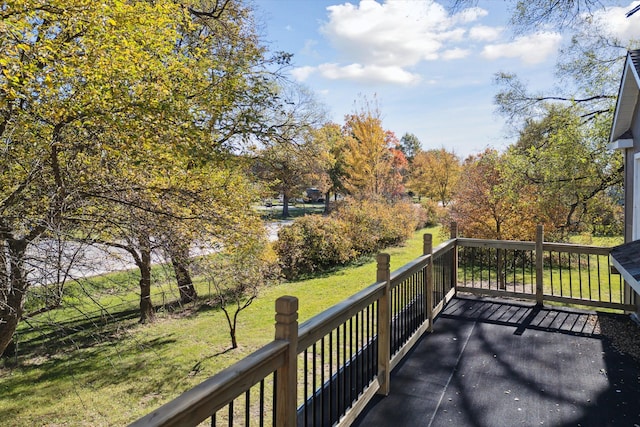 wooden deck featuring a lawn