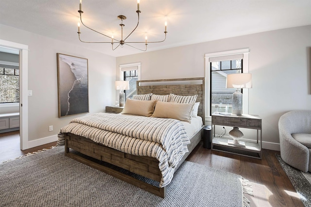 bedroom with baseboards, multiple windows, a notable chandelier, and hardwood / wood-style flooring