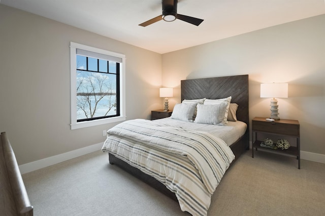 bedroom with a ceiling fan, baseboards, and light carpet