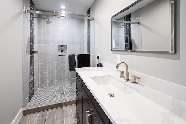 bathroom featuring vanity, a shower stall, and wood finished floors