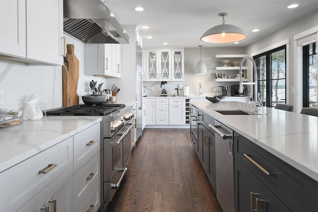 kitchen featuring white cabinets, appliances with stainless steel finishes, extractor fan, and a sink