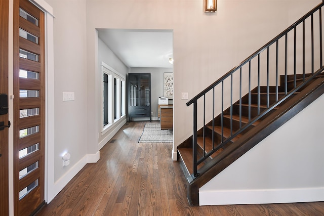 entrance foyer featuring stairway, visible vents, baseboards, and hardwood / wood-style floors