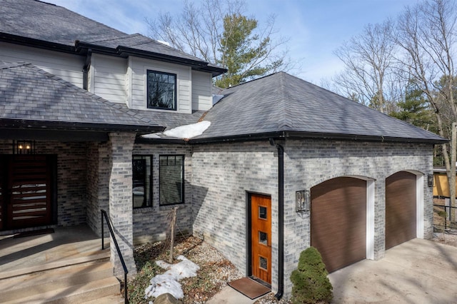 exterior space featuring concrete driveway, an attached garage, and covered porch