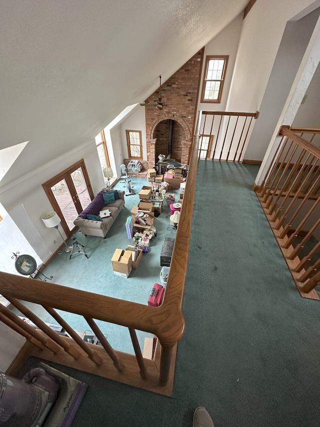 unfurnished living room featuring vaulted ceiling, carpet flooring, and a healthy amount of sunlight