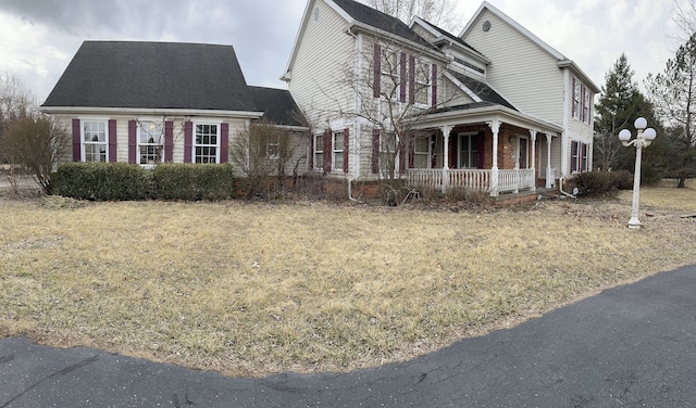 view of side of property featuring covered porch