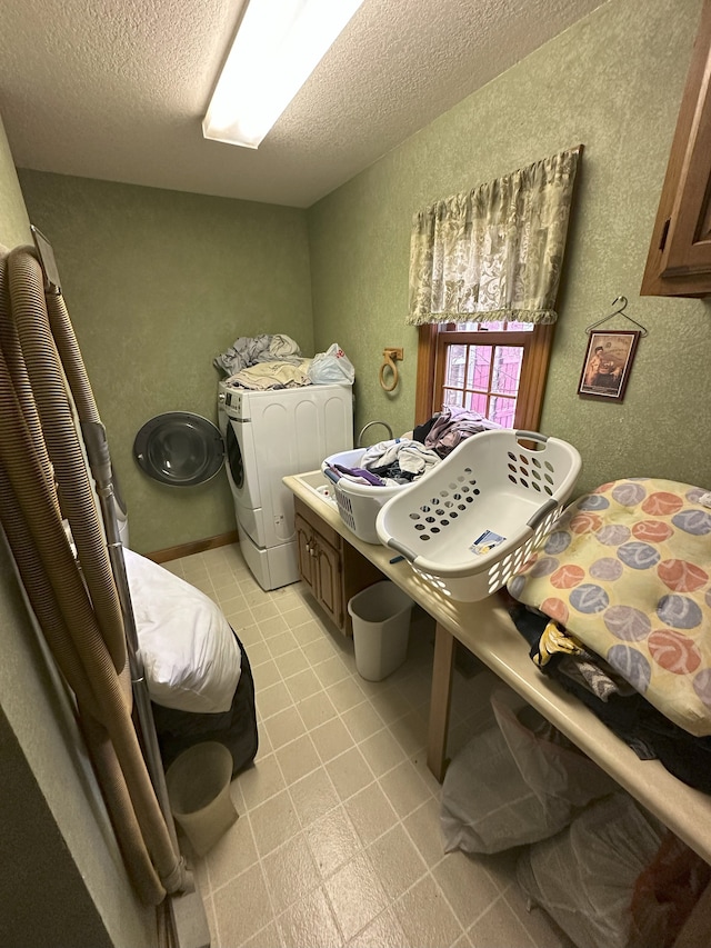washroom featuring a textured ceiling, cabinet space, separate washer and dryer, and a textured wall