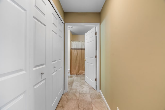 corridor featuring baseboards