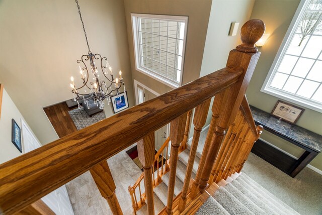 stairway featuring a high ceiling and a chandelier
