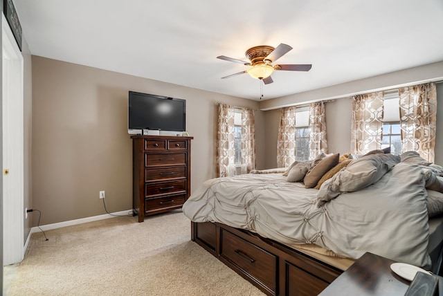 bedroom with baseboards, a ceiling fan, and light carpet