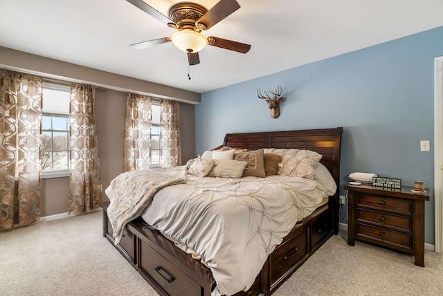bedroom with light colored carpet, baseboards, and ceiling fan