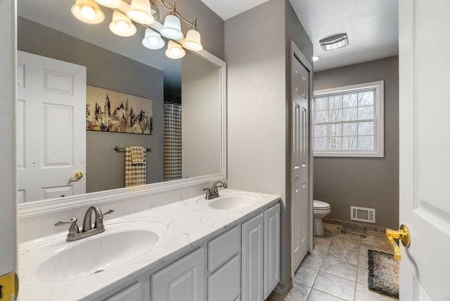 bathroom with visible vents, a sink, double vanity, and toilet