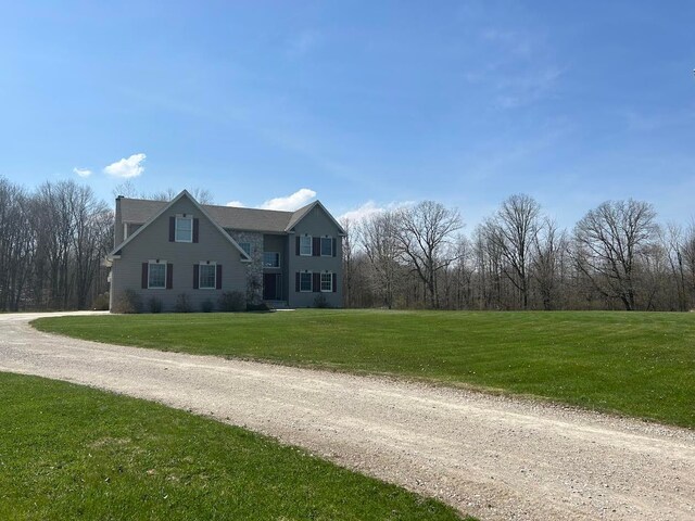 view of front of property with dirt driveway and a front yard