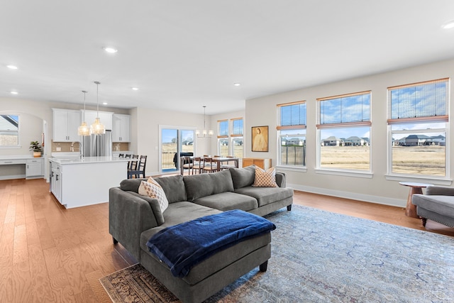 living room featuring recessed lighting, a chandelier, and light wood finished floors