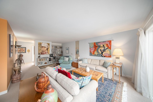 living area featuring light colored carpet and baseboards