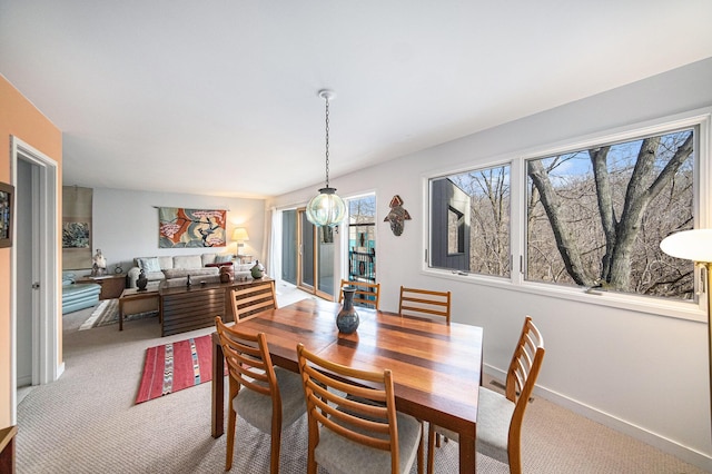 dining area featuring baseboards and light colored carpet