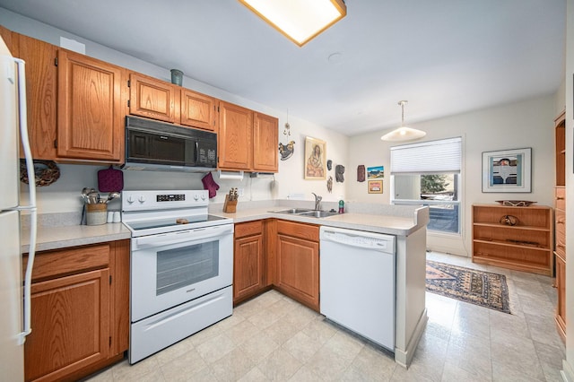 kitchen featuring a sink, white appliances, a peninsula, brown cabinetry, and light countertops