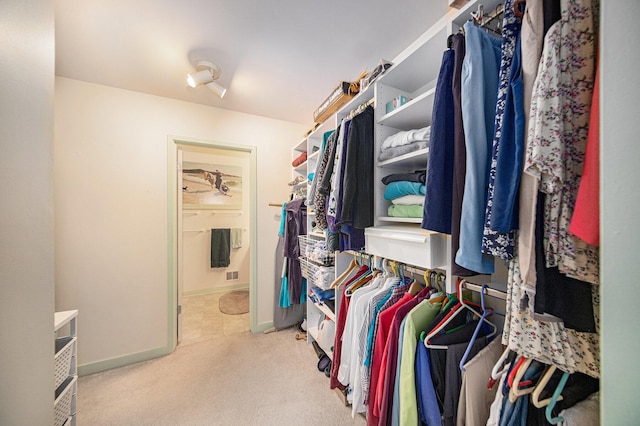 walk in closet featuring light carpet