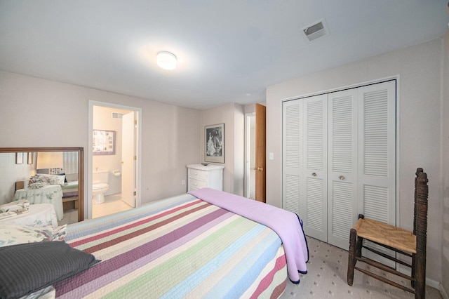 bedroom featuring a closet, visible vents, connected bathroom, and carpet floors