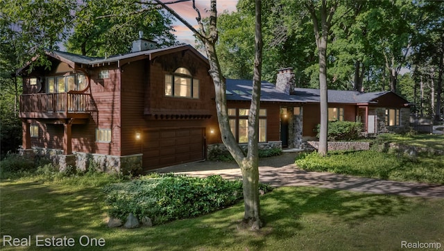 28190 Wildwood Trl, Farmington Hills, MI 48336 - view of front of house featuring a chimney, driveway, an attached garage, stone siding, and a yard