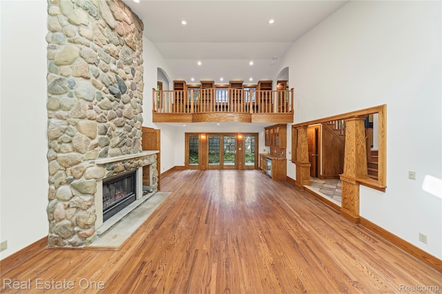 28190 Wildwood Trl, Farmington Hills, MI 48336 - unfurnished living room featuring a fireplace, wood finished floors, recessed lighting, and a towering ceiling