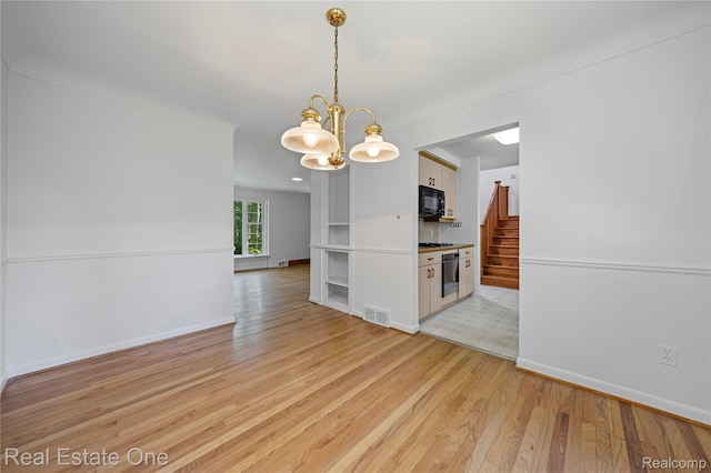 28190 Wildwood Trl, Farmington Hills, MI 48336 - spare room featuring a chandelier, light wood-style floors, and stairs