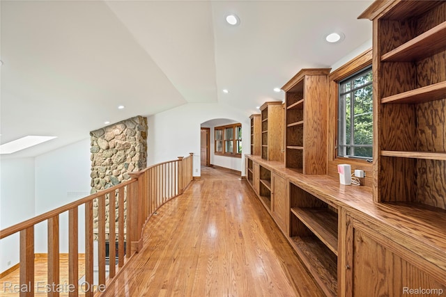 28190 Wildwood Trl, Farmington Hills, MI 48336 - hallway with light wood-type flooring, an upstairs landing, vaulted ceiling, a skylight, and arched walkways