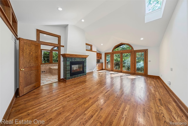 28190 Wildwood Trl, Farmington Hills, MI 48336 - unfurnished living room with lofted ceiling, a tile fireplace, wood finished floors, a skylight, and recessed lighting