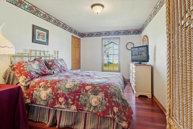 bedroom with baseboards and wood finished floors