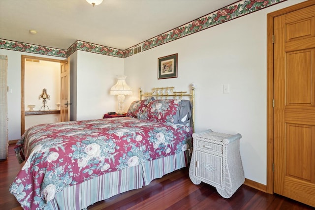 bedroom with baseboards and wood finished floors