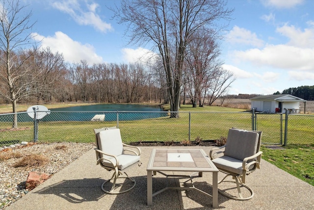 view of patio with a gate, fence, and a water view