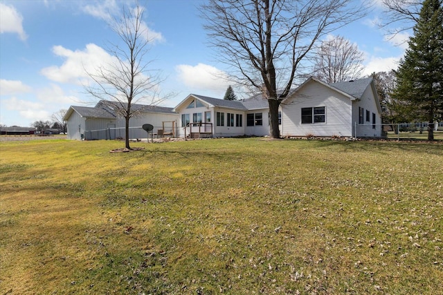 rear view of property with a yard and fence