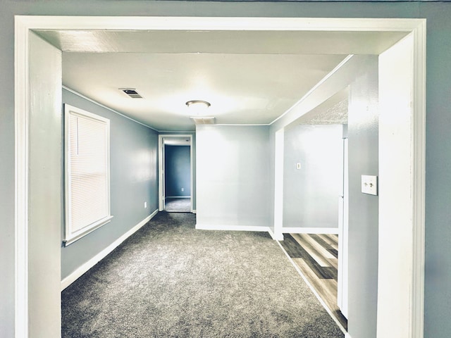 spare room featuring carpet floors, baseboards, and visible vents