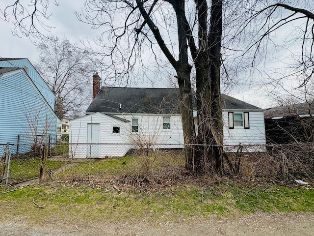 view of front of property featuring roof with shingles, a chimney, fence, and a gate