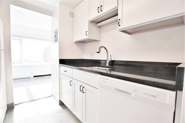 kitchen featuring a sink, dark countertops, white dishwasher, and white cabinetry