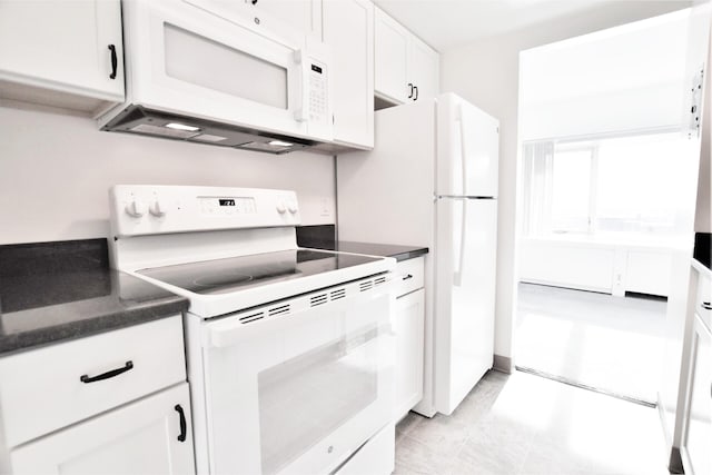 kitchen with white appliances, white cabinets, and dark countertops