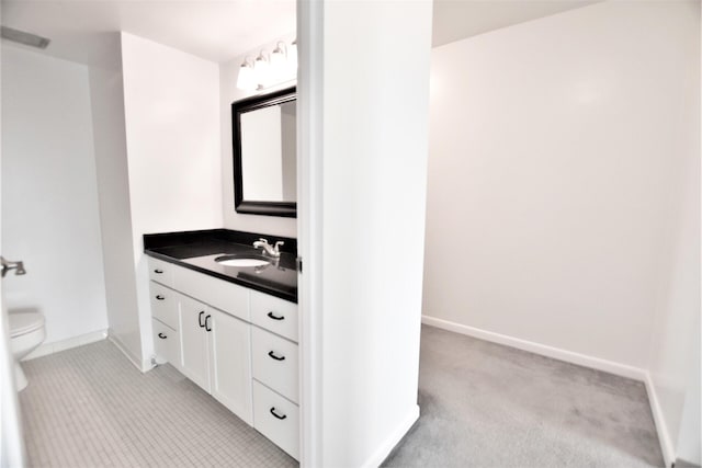 bathroom featuring vanity, toilet, and baseboards