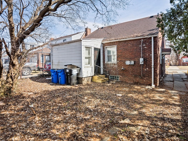 rear view of property with entry steps and a chimney