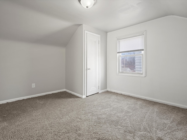 additional living space with vaulted ceiling, baseboards, and carpet floors
