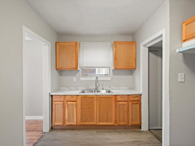 kitchen with a sink, light wood-type flooring, and light countertops