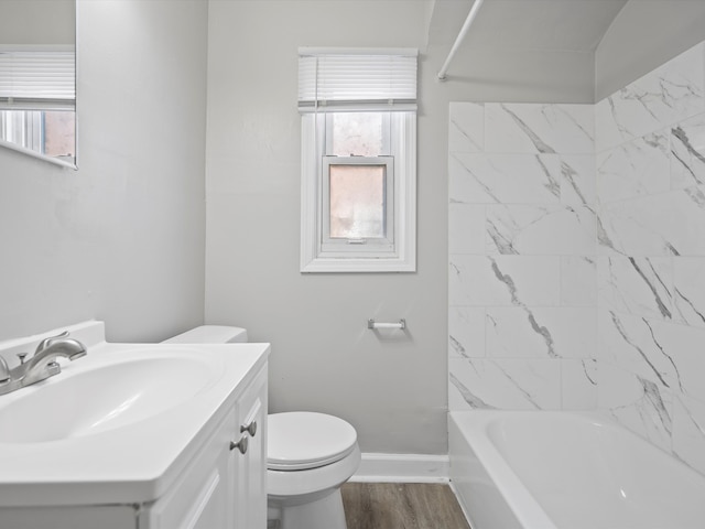 full bath featuring toilet, wood finished floors, baseboards, bathing tub / shower combination, and vanity