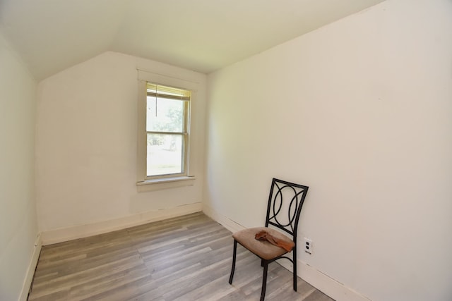 unfurnished room with vaulted ceiling, wood finished floors, and baseboards