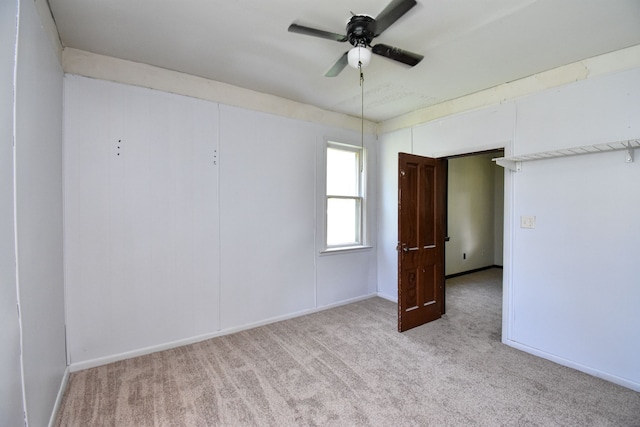 empty room featuring baseboards, carpet floors, and ceiling fan