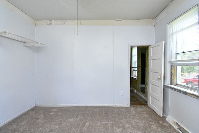 empty room with visible vents, baseboards, and carpet flooring