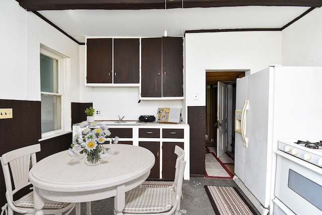 kitchen with dark brown cabinetry, white gas range oven, and light countertops