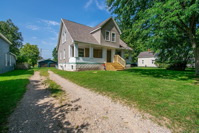 view of front of home featuring a porch, a front yard, roof with shingles, a garage, and driveway