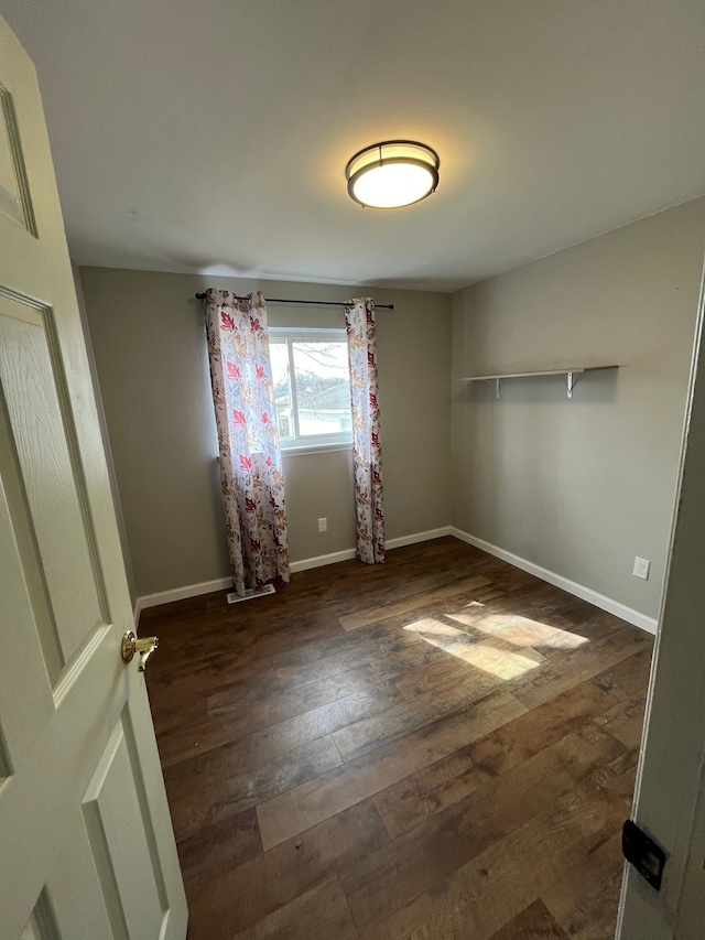 empty room with baseboards and wood finished floors