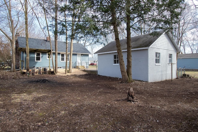 back of property with an outdoor structure and fence