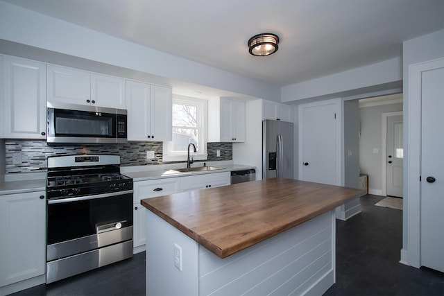 kitchen featuring a sink, white cabinetry, appliances with stainless steel finishes, butcher block counters, and decorative backsplash