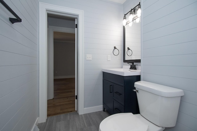 bathroom with toilet, wood finished floors, and vanity