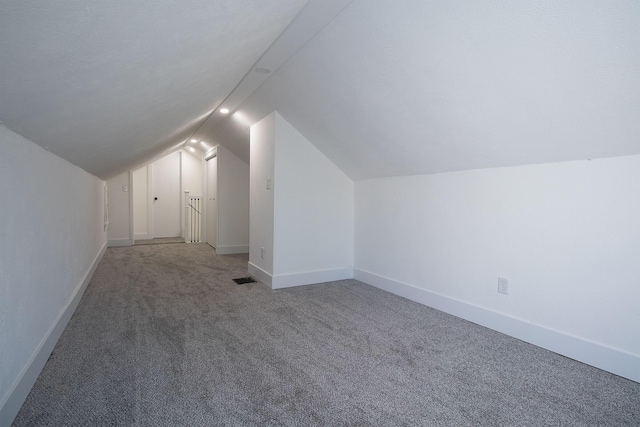bonus room featuring visible vents, baseboards, carpet floors, and vaulted ceiling